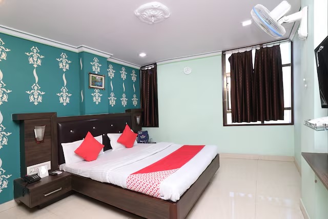 Deluxe Room at Hotel Madani - Spacious room with queen-sized bed, modern furnishings, and city views